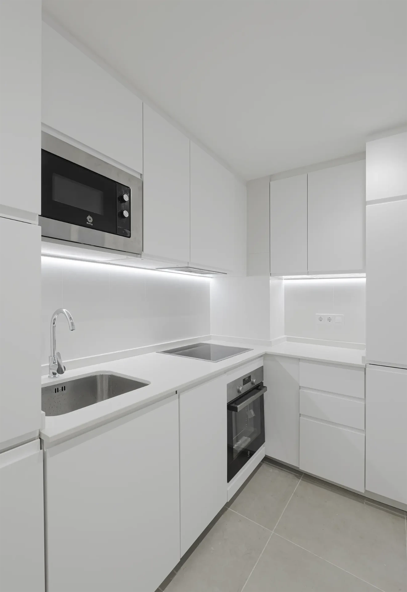 Cocina blanca en L con iluminación LED integrada