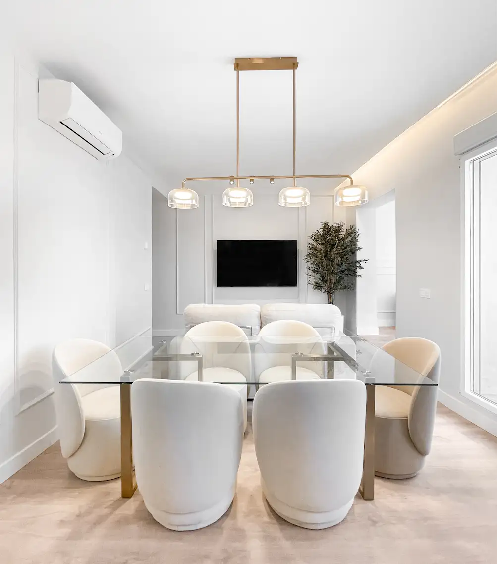 Salón comedor luminoso con mesa de cristal y sillas tapizadas